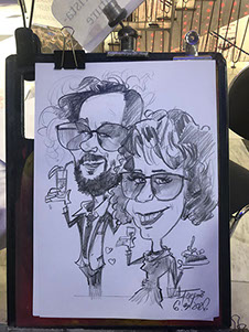 Zábavný program na oslavu 50-ky, hostia sa smejú na rýchlokresbách od karikaturistu Janka.