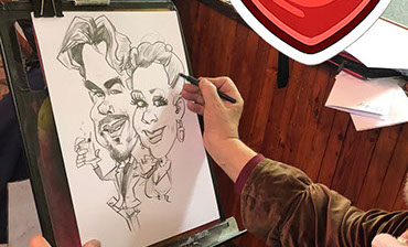 Malý chlapec sa radostne usmieva a v rukách drží svoju čerstvo nakreslenú karikatúru zo svadobnej oslavy.